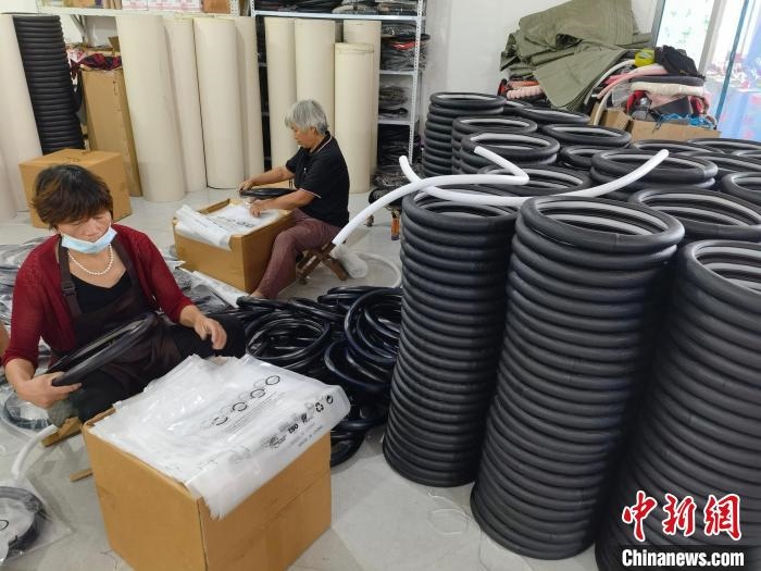 圖為村民在汽車飾品企業(yè)生產(chǎn)車間中工作?！巫雍?攝