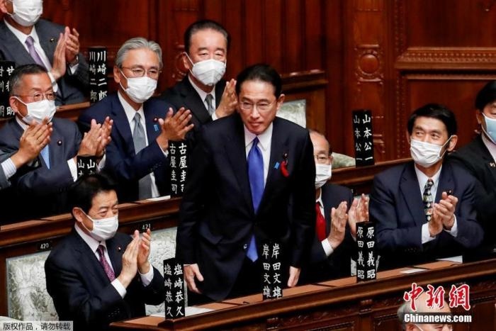 當?shù)貢r間10月4日，日本自民黨總裁岸田文雄經(jīng)過眾院全體會議的首相指名選舉成為第100任首相。圖為岸田文雄（中）起身致謝。