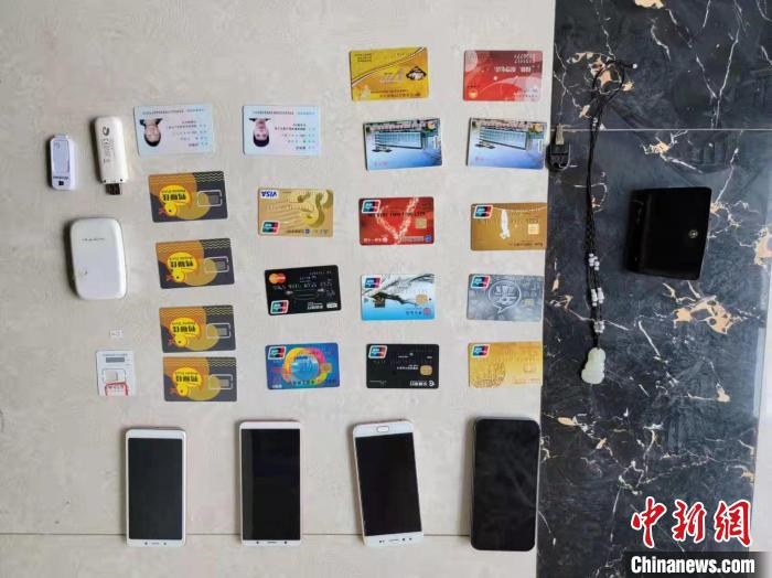 資料圖為果洛藏族自治州公安民警查扣的作案手機和涉案銀行卡?！‖斍呖h公安局供圖