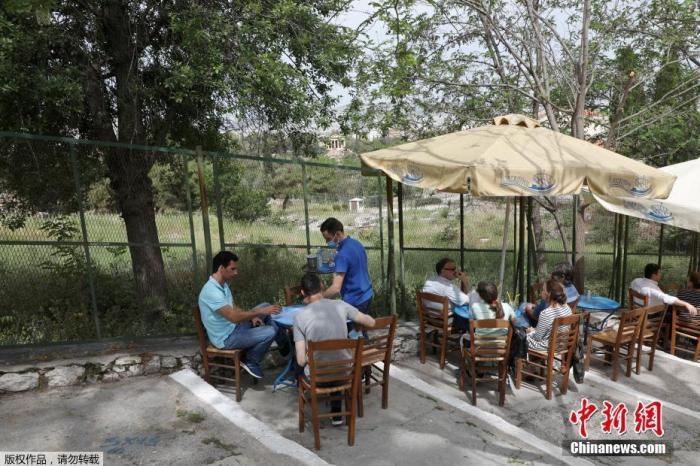 資料圖：希臘雅典，人們在一家露天咖啡享用飲品。