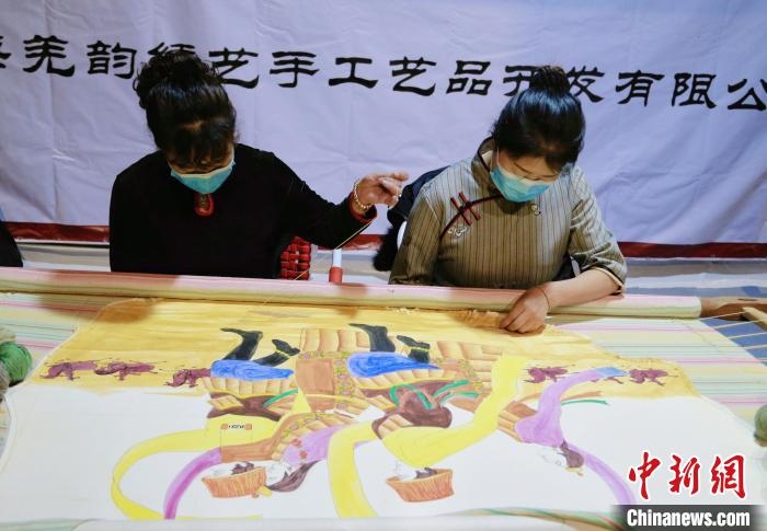 圖為皮繡藝人在市集上“秀”指尖技藝?！●R銘言 攝