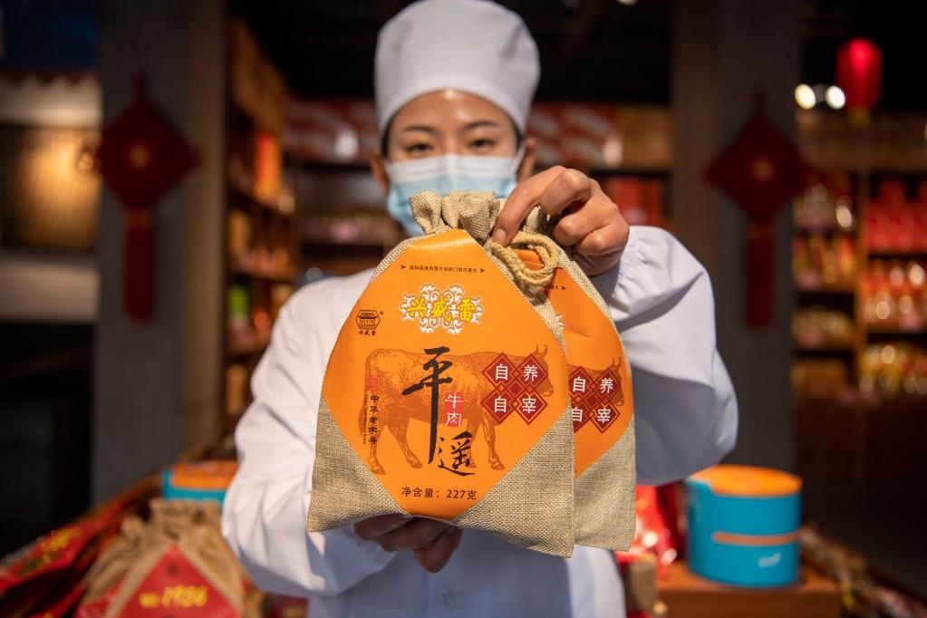 1月27日，在平遙古城南大街的一家平遙牛肉店內(nèi)，工作人員展示一款牛肉產(chǎn)品。新華社記者 楊晨光 攝