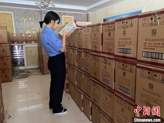 資料圖為檢察人員核對查獲的假冒品牌白酒。青海省人民檢察院供圖