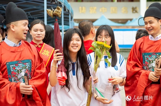 6月7日上午，在南寧市天桃實(shí)驗(yàn)學(xué)校翠竹校區(qū)，老師們?cè)跒榭忌鷤兗佑凸膭?！人民網(wǎng)記者 嚴(yán)立政攝