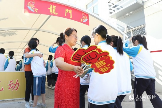 6月7日一早，雄安新區(qū)安新中學(xué)老師在給同學(xué)們加油鼓勁兒。人民網(wǎng) 李兆民攝