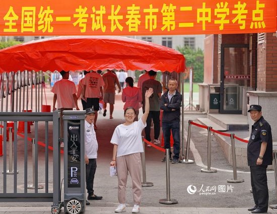 6月7日，在長(zhǎng)春市第二中學(xué)考點(diǎn)，一名考生信心滿滿進(jìn)入考場(chǎng)，并與家長(zhǎng)揮手致意。人民網(wǎng)記者 李洋攝