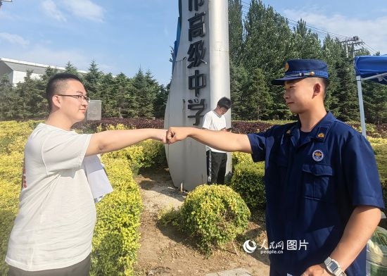 6月7日，遼寧營(yíng)口老邊區(qū)消防救援大隊(duì)的消防員為高考學(xué)子加油助威。人民網(wǎng)記者 尹柏寒?dāng)z