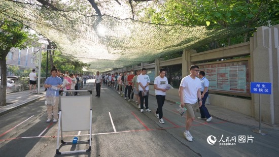 6月7日，烏魯木齊市第七十中學(xué)門口，考生們有序進(jìn)入考場(chǎng)。人民網(wǎng) 李欣洋攝