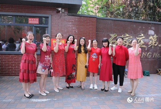 6月7日，在石家莊第二十七中學(xué)考點(diǎn)，家長(zhǎng)身著旗袍，為高考的孩子們加油助威！紅紅火火、旗開(kāi)得勝！人民網(wǎng)記者 周博攝