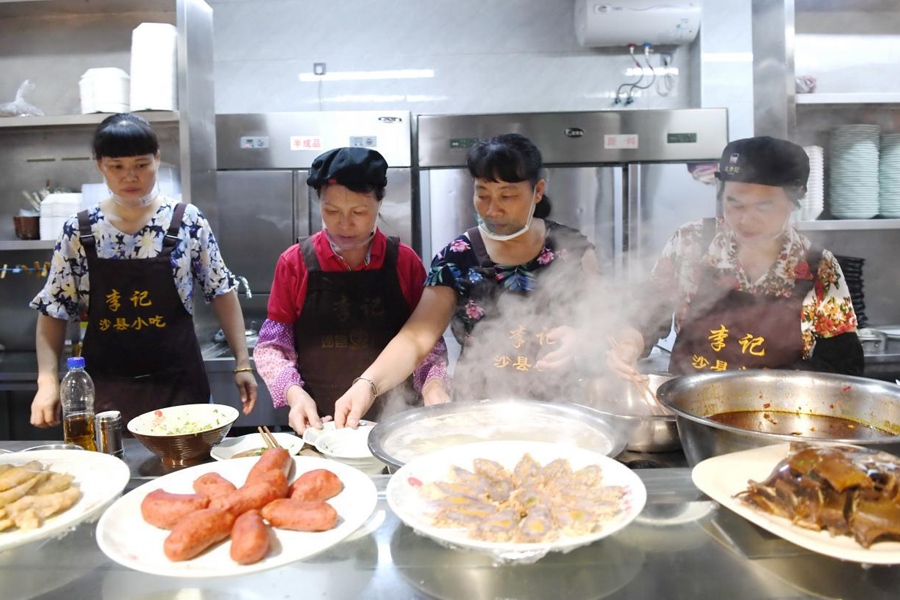 福建三明市沙縣區(qū)一家小吃店工作人員在為客人準(zhǔn)備特色小吃。 新華社記者 林善傳 攝
