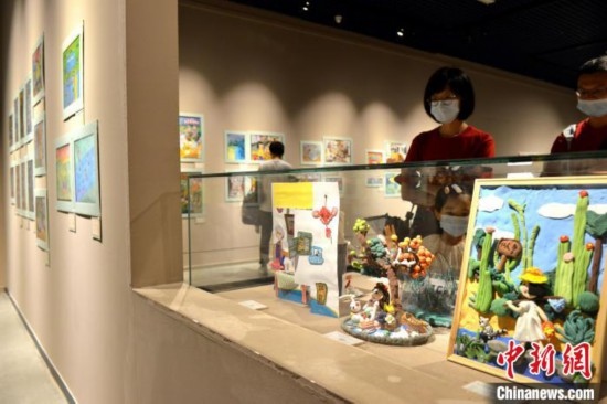 圖為家長帶著孩子參觀展覽。呂明 攝