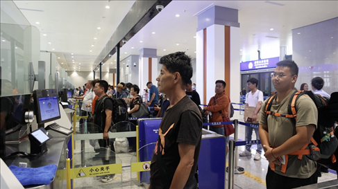 6月13日，乘坐中老鐵路國際旅客列車的旅客在磨憨邊檢大廳排隊(duì)候檢。李揚(yáng) 攝