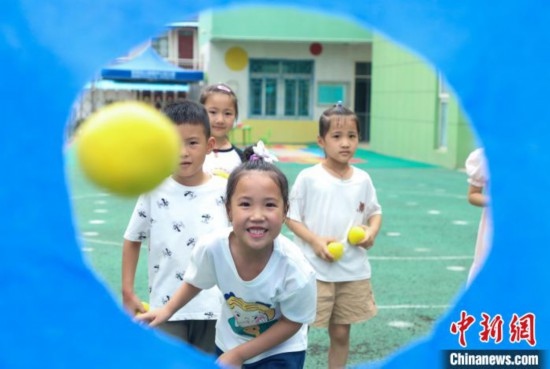 在肥西縣山南鎮(zhèn)中心幼兒園，孩子們在玩布洞投球游戲。陳家樂 攝