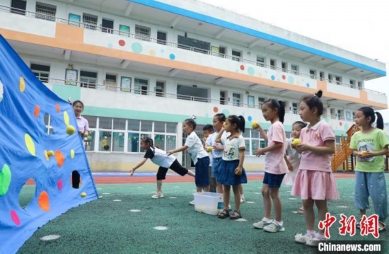 在肥西縣山南鎮(zhèn)中心幼兒園，孩子們在玩布洞投球游戲。陳家樂 攝