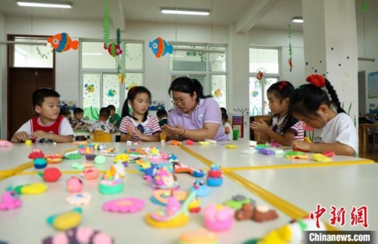在肥西縣山南鎮(zhèn)中心幼兒園，孩子們在老師的指導(dǎo)下做彩色泥塑。陳家樂 攝
