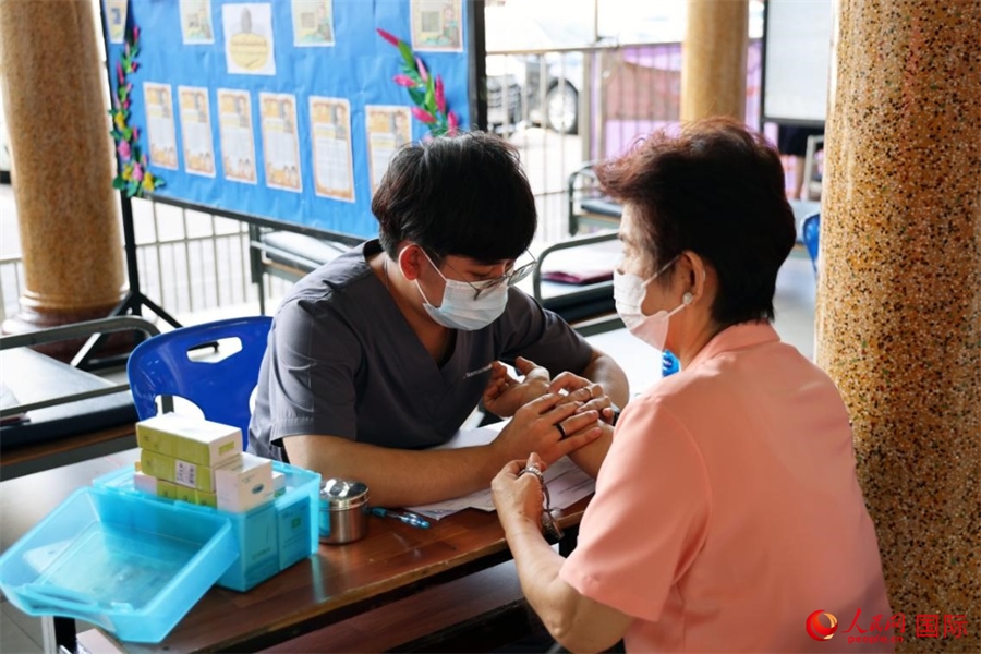 泰國中醫(yī)師為當?shù)孛癖娞峁┲嗅t(yī)咨詢、診療服務。人民網(wǎng)記者 楊一攝