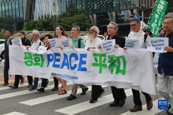 7月22日，在韓國首爾，人們手舉標(biāo)語參與反戰(zhàn)游行。新華社發(fā)（楊暢 攝）