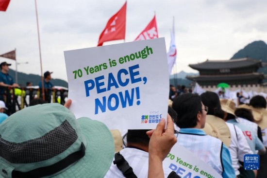 7月22日，在韓國首爾，人們手舉標(biāo)語參與反戰(zhàn)游行。新華社發(fā)（楊暢 攝）