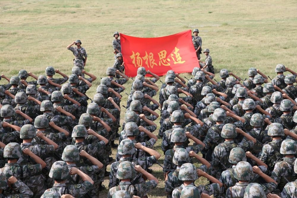 ↑“楊根思連”官兵執(zhí)行任務(wù)前向連旗宣誓（資料照片）。新華社發(fā)