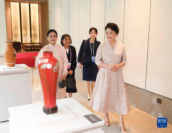 7月27日下午，國(guó)家主席習(xí)近平夫人彭麗媛在四川成都會(huì)見陪同印度尼西亞總統(tǒng)佐科來華出席第31屆世界大學(xué)生夏季運(yùn)動(dòng)會(huì)開幕式并訪華的總統(tǒng)夫人伊莉亞娜。這是彭麗媛和伊莉亞娜欣賞成都特色非遺工藝品。新華社記者 丁林 攝