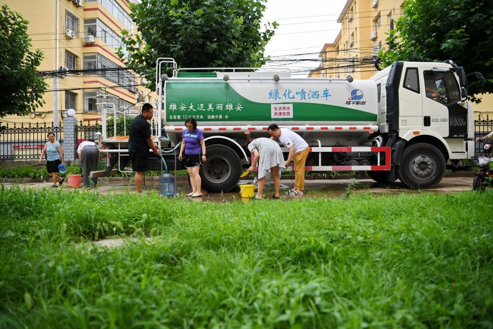 河北省涿州市新星小區(qū)居民從供水車?yán)锝铀?月4日攝）。新華社記者 牟宇 攝