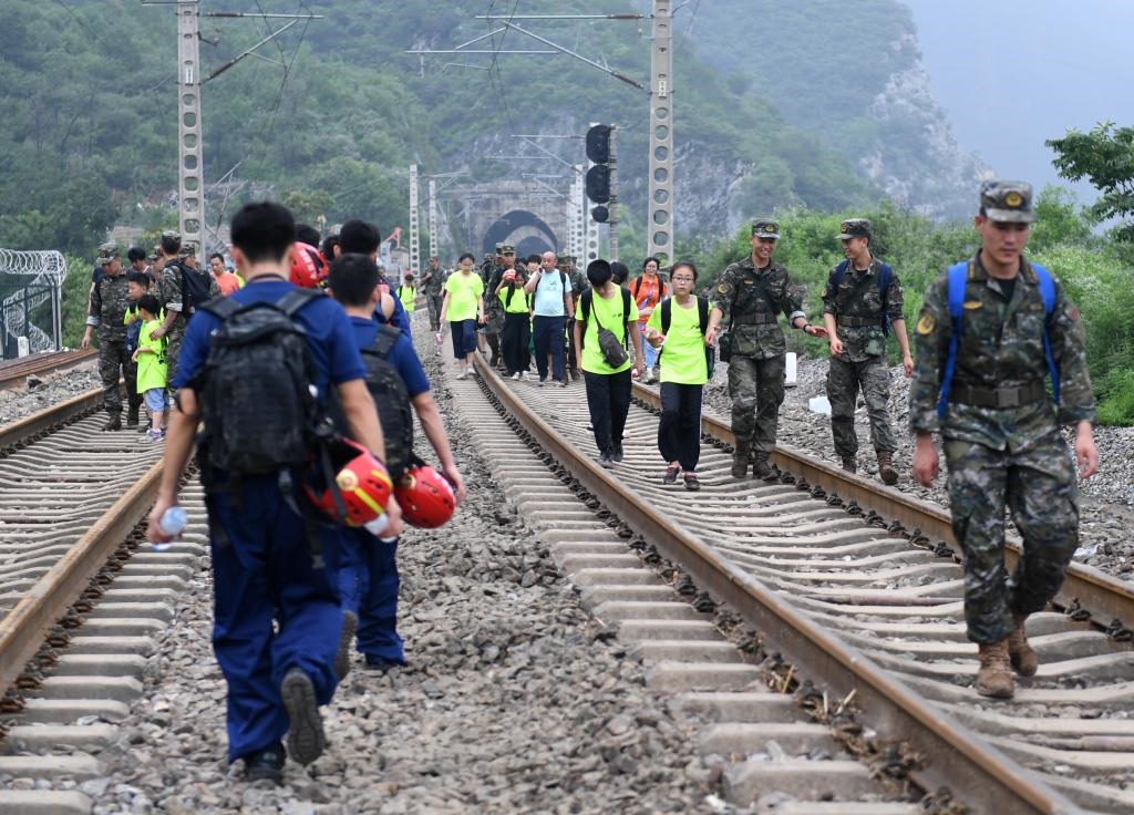 8月2日，部分滯留在北京市門頭溝山區(qū)受困列車的旅客，在救援人員幫助下前往轉(zhuǎn)運客車。新華社記者張晨霖 攝