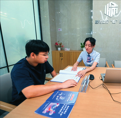 在杭州市臨安區(qū)政務(wù)服務(wù)中心的“為企服務(wù)中心”，黨員志愿者（右）解答企業(yè)主的疑問（2023年7月7日攝）。徐昱攝/本刊