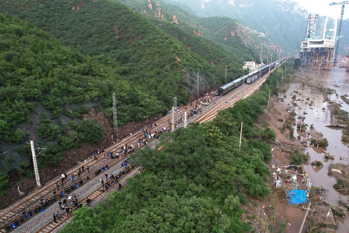 8月2日，受困列車旅客在救援人員幫助下徒步趕往轉(zhuǎn)運客車（無人機照片）。新華社記者 張晨霖 攝