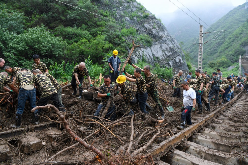 8月1日，在北京市門頭溝區(qū)水峪嘴村附近一段被阻斷的鐵路線上，中鐵六局工作人員在清理軌道上的雜物，全力恢復交通。新華社記者 鞠煥宗 攝