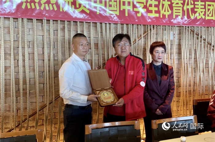 巴西中國和平統(tǒng)一促進會會長王俊曉向中國中學(xué)生體育代表團團長劉立新贈送紀念品。人民網(wǎng)記者 宋亦然攝