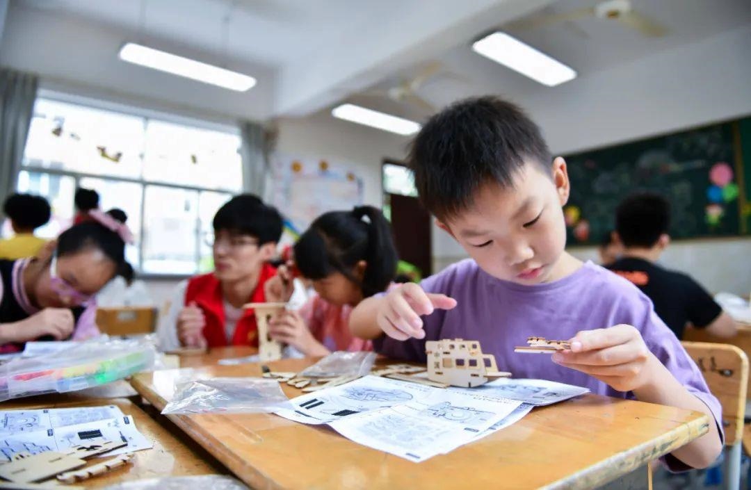 △今年7月，在浙江余姚市舜北小學(xué)暑托班內(nèi)，孩子們制作太陽能科學(xué)實(shí)驗(yàn)裝置。