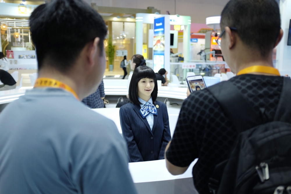 9月1日，媒體記者在國家會議中心與服務機器人互動。新華社記者 劉夢琪 攝