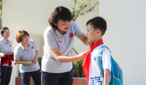 8月30日，雄安史家胡同小學(xué)學(xué)生體驗(yàn)學(xué)校生活。老師為學(xué)生佩戴校徽。