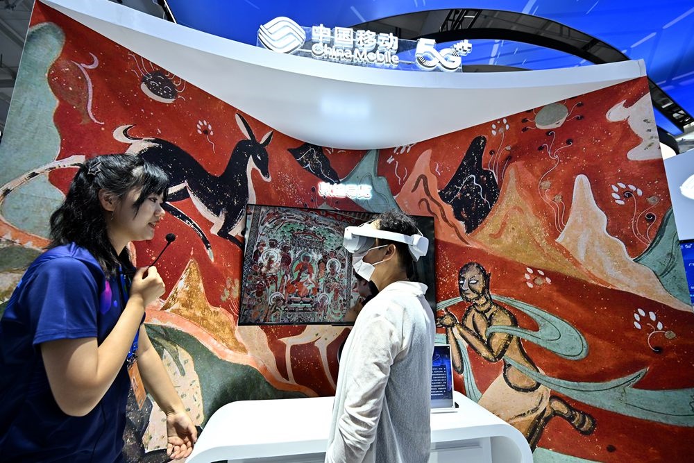 9月3日，一名參觀者在首鋼園中國移動展臺體驗(yàn)基于AR/VR特效的敦煌導(dǎo)覽，沉浸式感受敦煌壁畫的魅力。新華社記者 李鑫 攝