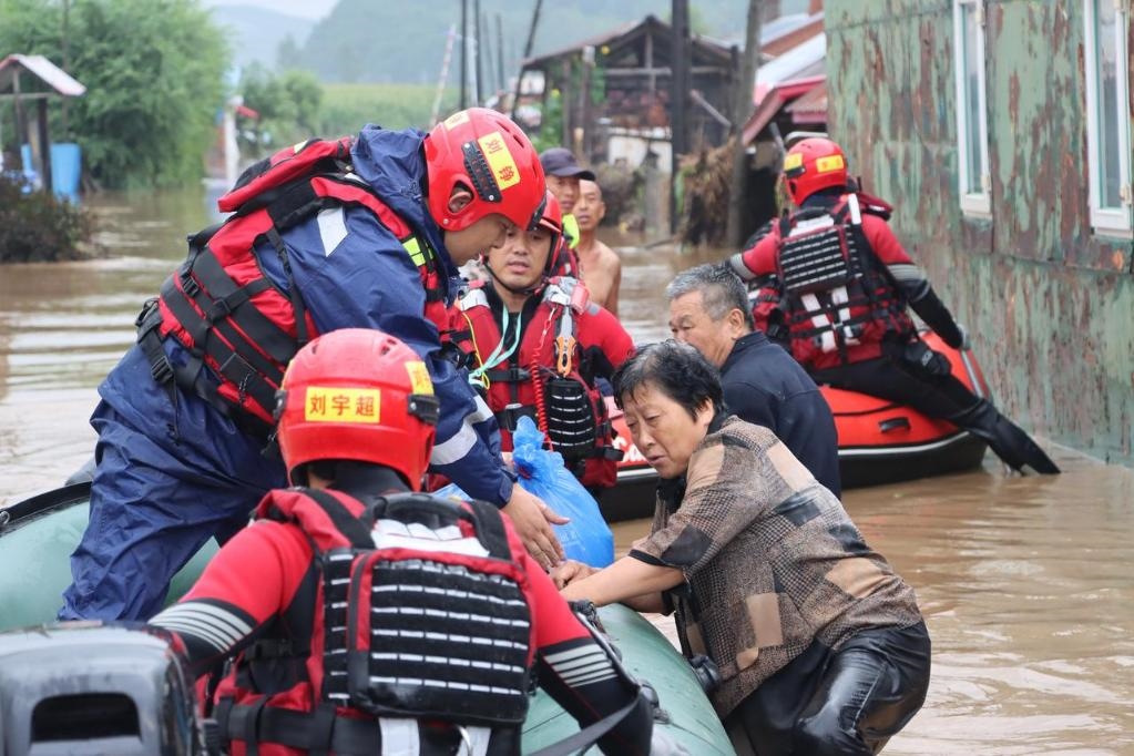 8月4日，在黑龍江省尚志市一面坡鎮(zhèn)萬(wàn)山村，哈爾濱市森林消防支隊(duì)的消防員在解救被困村民。新華社發(fā)