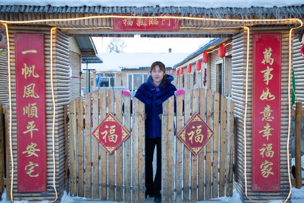 北極村民宿經(jīng)營(yíng)者史瑞娟在門前迎候入住的游客（2023年1月7日攝）。