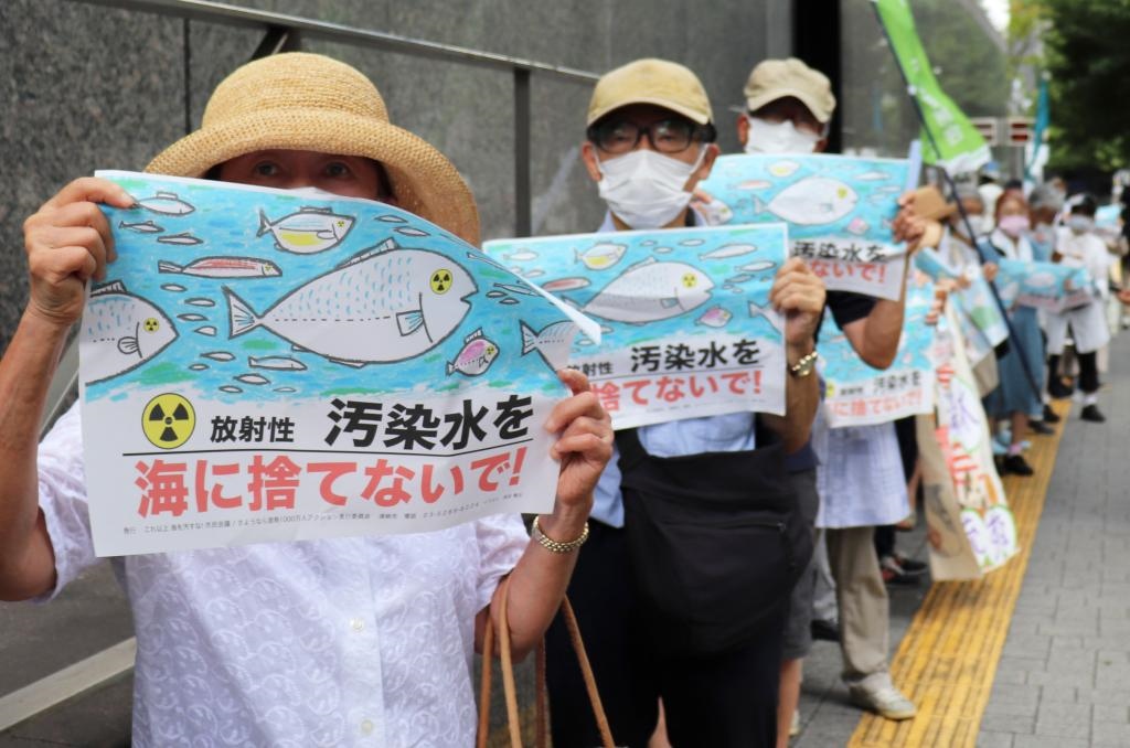 8月24日，日本民眾手持“不要將污染水扔進(jìn)大?！钡葮?biāo)語在東京電力公司總部前集會(huì)，抗議日本政府和東電公司無視民意啟動(dòng)核污染水排海。新華社記者楊光攝