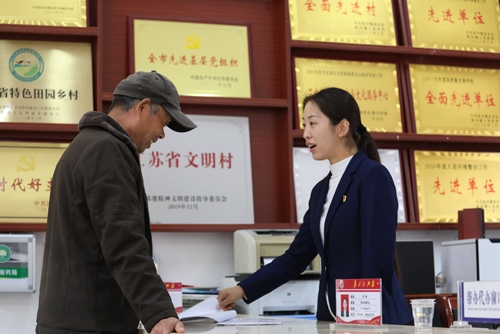 李敏在雙蕩村便民服務(wù)大廳接待前來辦理業(yè)務(wù)的村民。受訪者供圖