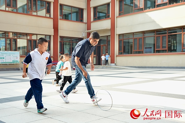 來(lái)自巴基斯坦的沙杰在滾鐵環(huán)。人民網(wǎng) 盧鵬宇攝