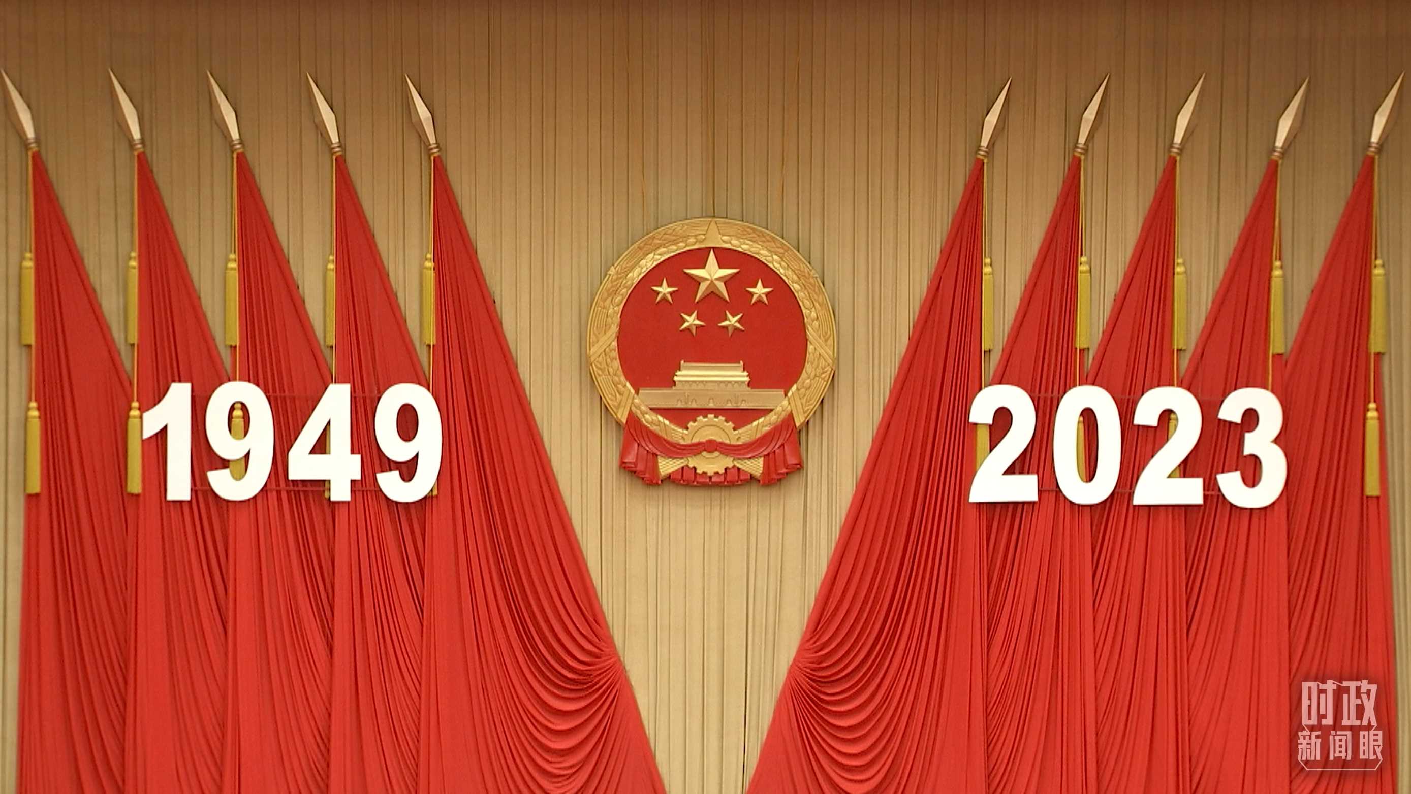 △人民大會堂宴會廳內(nèi)，主席臺上方高懸著莊嚴(yán)的國徽，“1949－2023”大字年號在鮮艷的紅旗映襯下格外醒目。