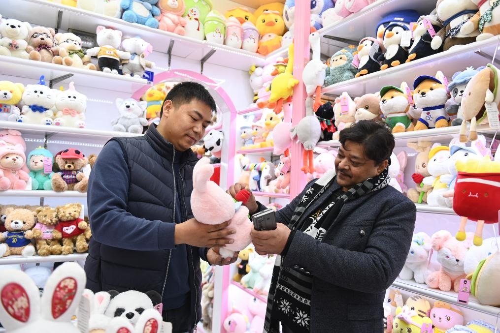 2023年2月2日，來自印度的客商（右）在義烏國(guó)際商貿(mào)城的一家玩具店鋪內(nèi)選購商品。新華社記者 黃宗治 攝