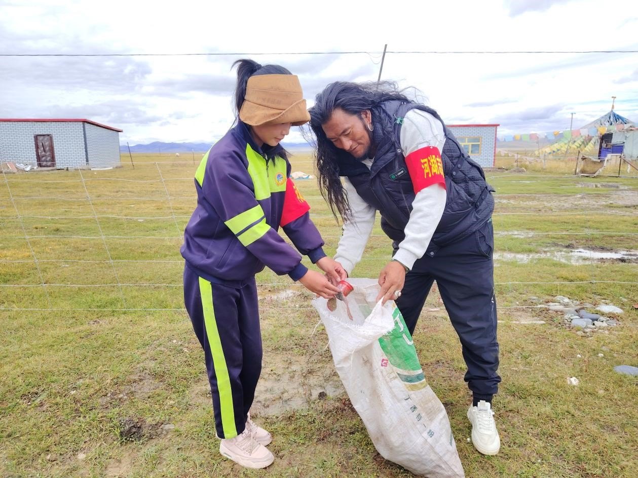 玉樹州稱多縣珍秦鎮(zhèn)河湖志愿者才培和他女兒更求拉毛在清掃垃圾。受訪者供圖