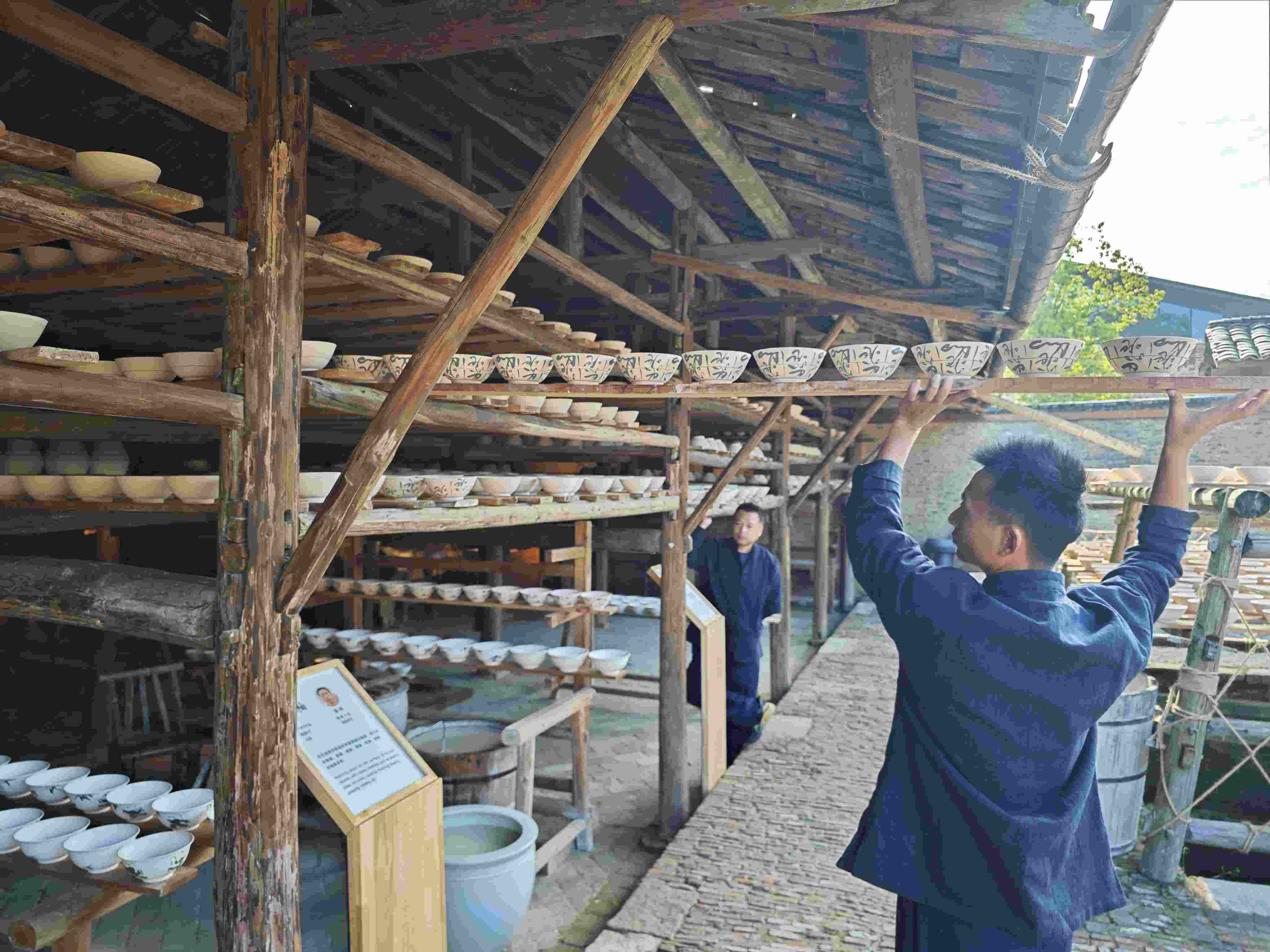 △陶陽(yáng)里歷史文化街區(qū)里，工匠將陶瓷工藝品放到架上晾干。（總臺(tái)央視記者彭漢明拍攝）