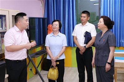 圖③：“小公民法律課堂”開講前，全國(guó)人大代表殷其龍（右二）、重慶市人大代表李自玲（左二）聽取楊家坪中學(xué)負(fù)責(zé)人關(guān)于未成年人思想教育工作情況的介紹。
