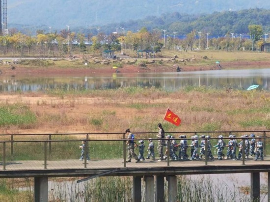 10月24日，秋游的幼兒園小朋友在老師帶領(lǐng)下走在清水塘公園里的木橋上。本報(bào)記者 常雯宜攝