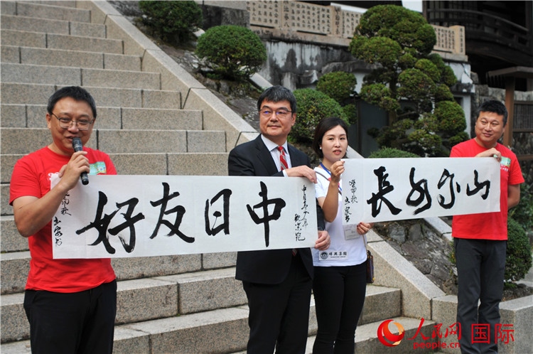 東京中國文化中心主任羅玉泉展示其為本次活動(dòng)書寫的題詞“中日友好，山高水長”。人民網(wǎng) 蔣曉辰攝