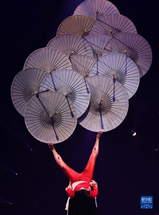 12月8日，演員在法國(guó)巴黎舉行的中國(guó)雜技“奇妙之夜”演出上表演《蹬傘》。新華社記者 高靜 攝