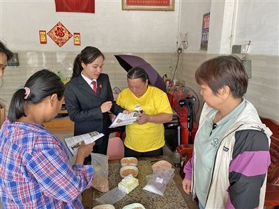  圖⑤：龍圩區(qū)法院法官到群眾家中開展法治宣傳。資料圖片