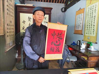 越南首都河內(nèi)文廟內(nèi)，阮明珠展示“中越心相近”書法作品。