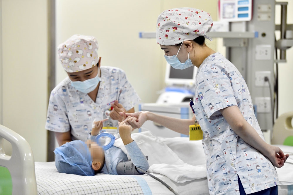 在山東省棗莊市婦幼保健院兒童ICU病房，醫(yī)護(hù)人員為完成靶向治療藥物諾西那生鈉的4歲脊髓性肌萎縮癥患兒加油鼓勁（2022年1月1日攝）。諾西那生鈉注射液是我國(guó)首個(gè)獲批治療脊髓性肌萎縮癥的進(jìn)口藥物，2019年進(jìn)入中國(guó)市場(chǎng)時(shí)，每針價(jià)格近70萬(wàn)元。在2021年國(guó)家醫(yī)保目錄藥品談判中，以3.3萬(wàn)元每針的價(jià)格進(jìn)入新版醫(yī)保藥品目錄。新華社記者 郭緒雷 攝
